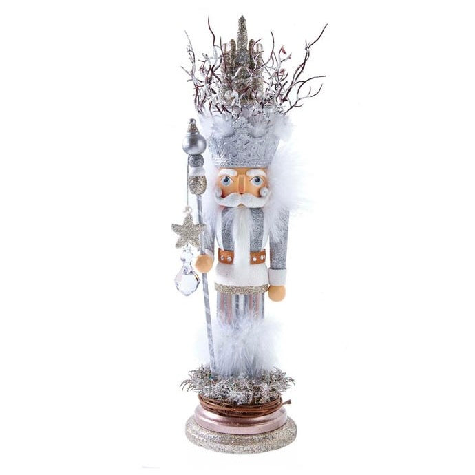 This Hollywood™ Castle King Nutcracker features a white and silver color scheme with a silver glittered castle hat. He is standing on a silver glittered base and is holding a white and silver staff with a star and clear gem dangle.